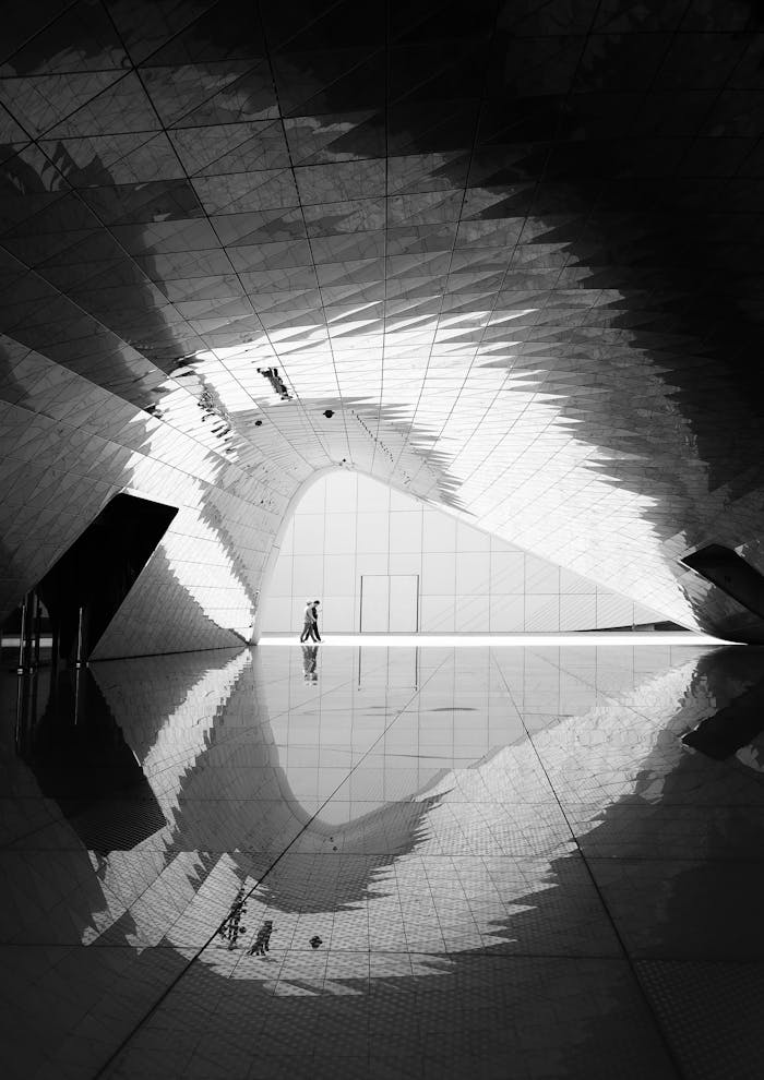 Grayscale Photo of Two Man Walking on Floor Tiles